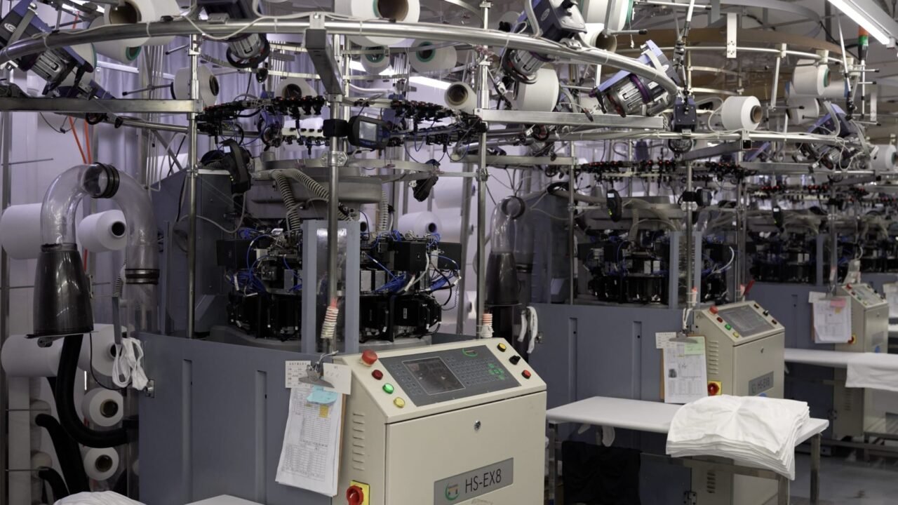 Large-cylinder Santoni seamless circular knitting machine at YOUMEGA Yiwu factory — body-mapped seamless activewear manufacturing for Western sizing up to 3XL