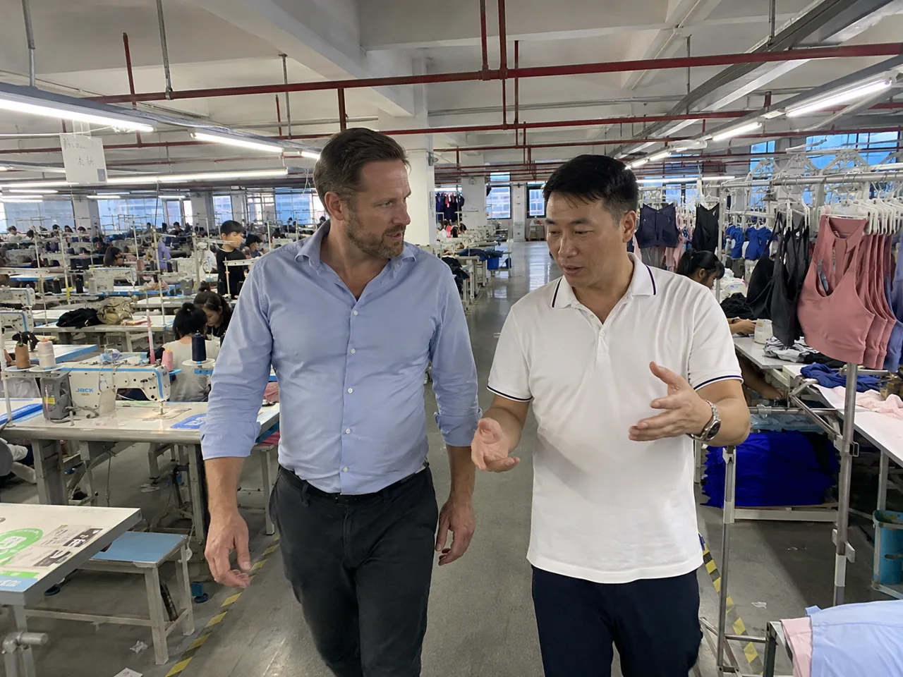 A brand founder walking the YOUMEGA production floor during a factory visit