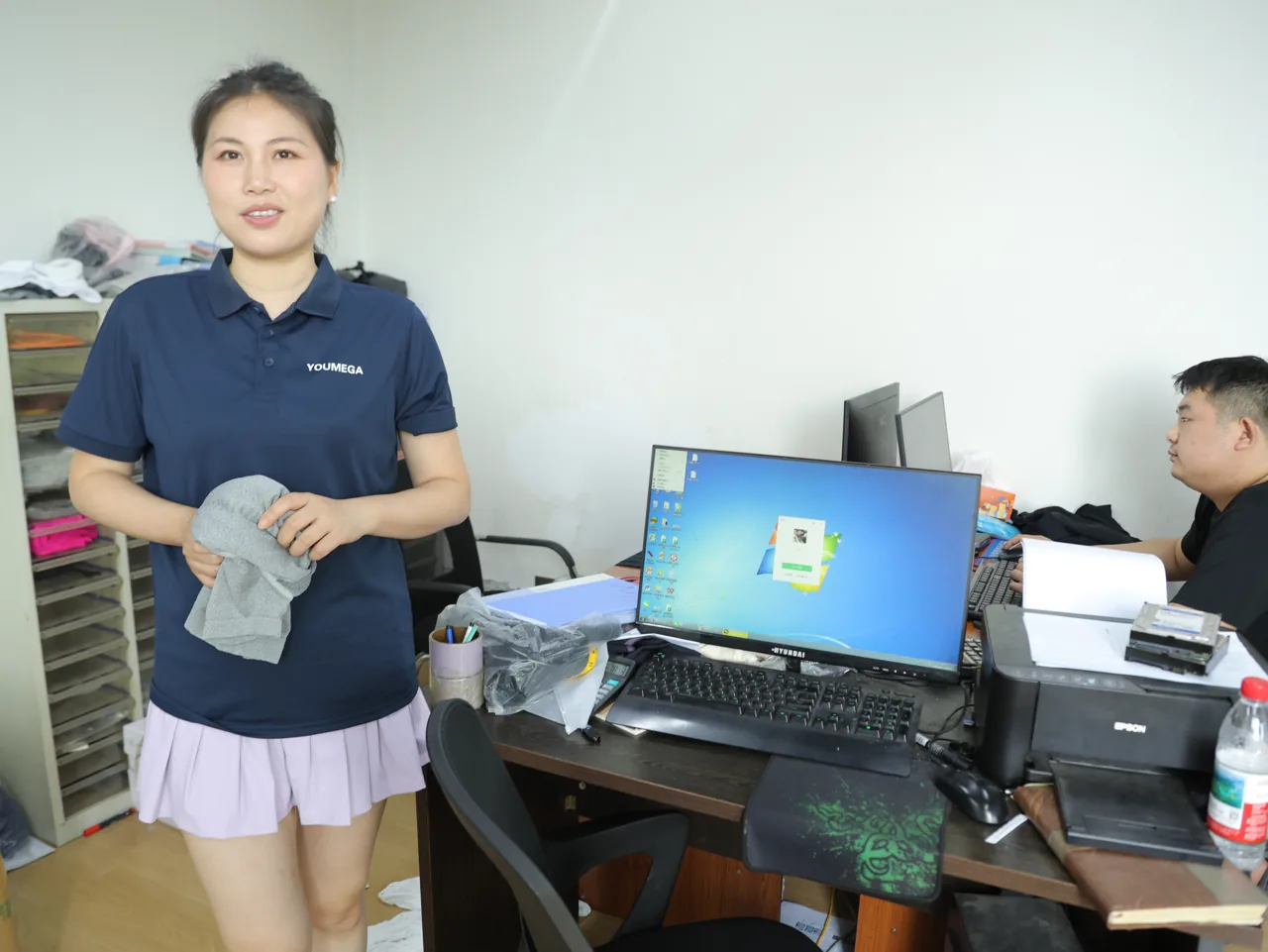 Personal de YOUMEGA revisando una muestra de activewear contra el tech pack
