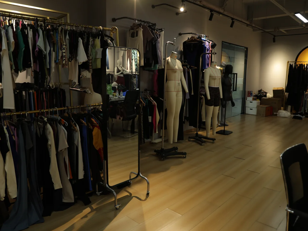 Rack of YOUMEGA activewear samples across sizes and styles