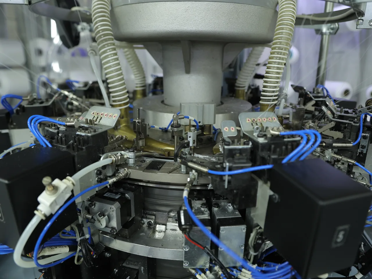 Large-cylinder Santoni seamless knitting machine cylinder and yarn feeds at YOUMEGA