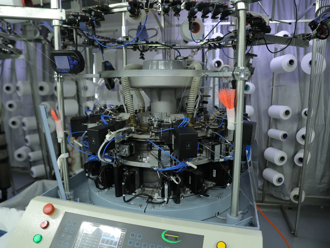 Close-up of a seamless circular knitting machine head knitting activewear at YOUMEGA